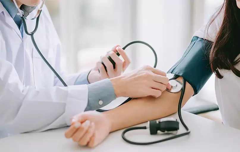 Un cardiologue mesure la tension artérielle d'un patient pour diagnostiquer l'hypertension. 